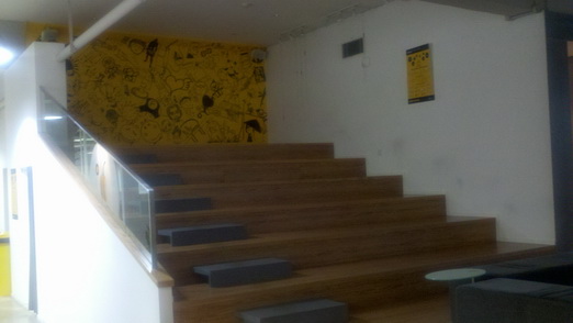 是会议场地还是偷闲楼梯呢？背景墙是一大块的涂鸦黄色设计稿